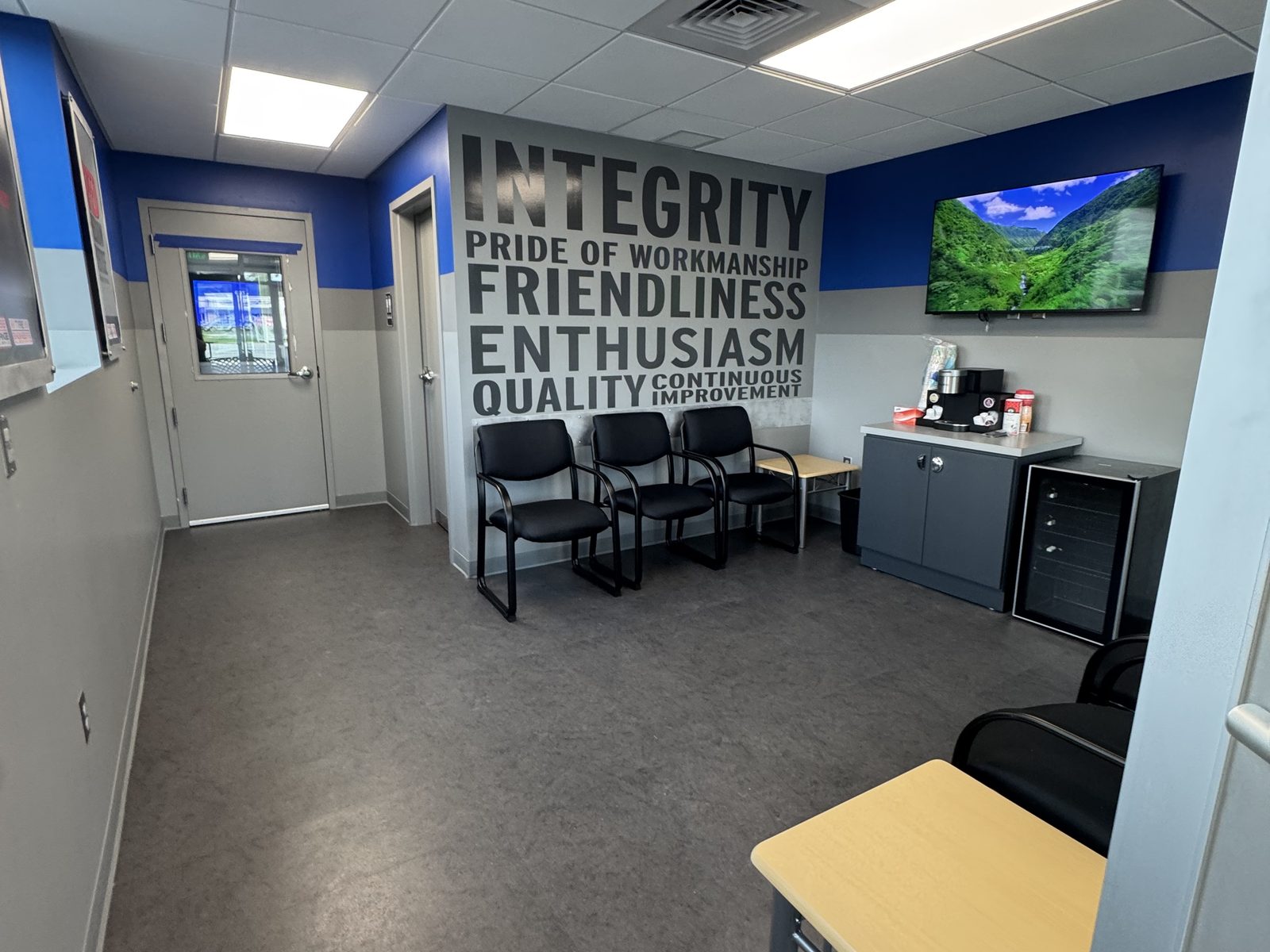 Customer waiting lobby at an auto service facility with cleaned floors, seating and coffee station