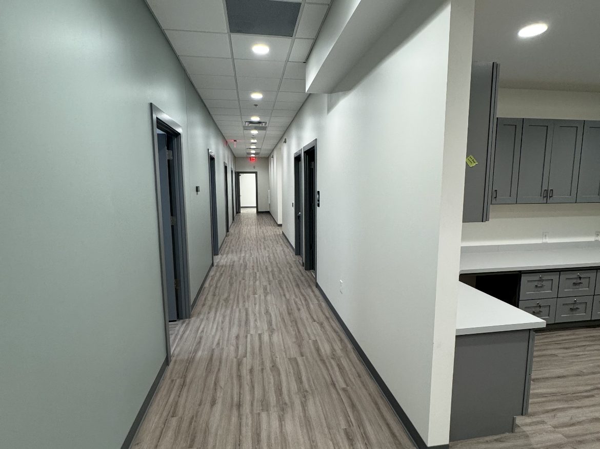 Office corridor and break area with cleaned floors, cabinetry and countertops ready for turnover