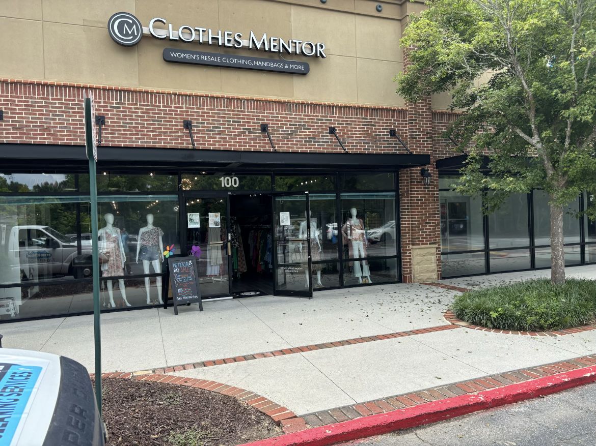 Retail storefront entrance and walkway at a shopping center under recurring maintenance